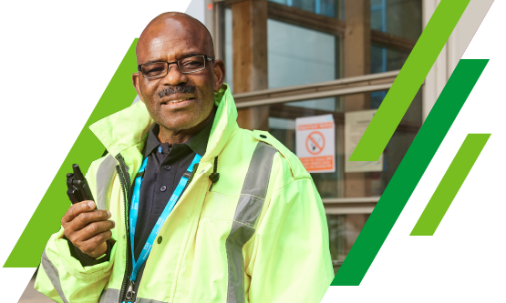 NHS security professional standing outside of a hospital setting with a high visibility jacket on