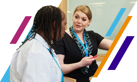 Non-Clinical NHS professional talking to a clinical healthcare professional and pointing at a computer screen